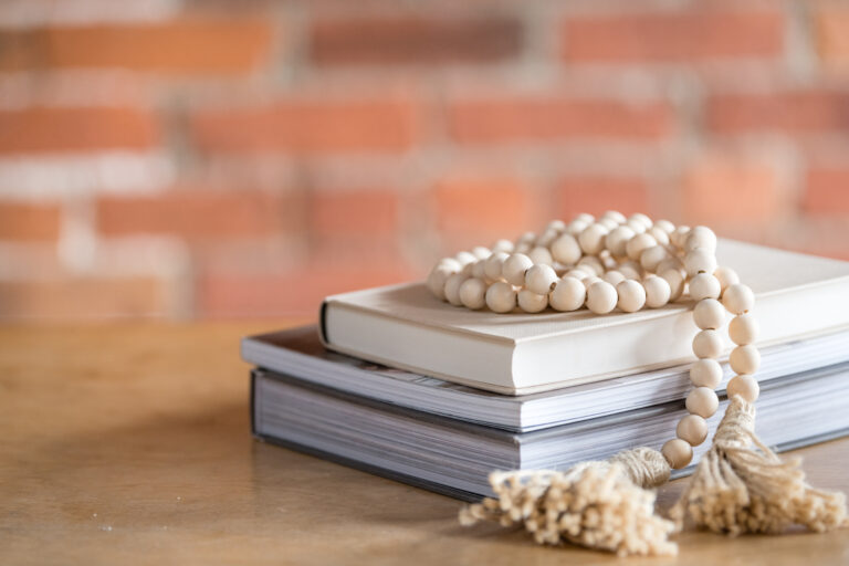 3 books sitting on a table with a red brick wall background