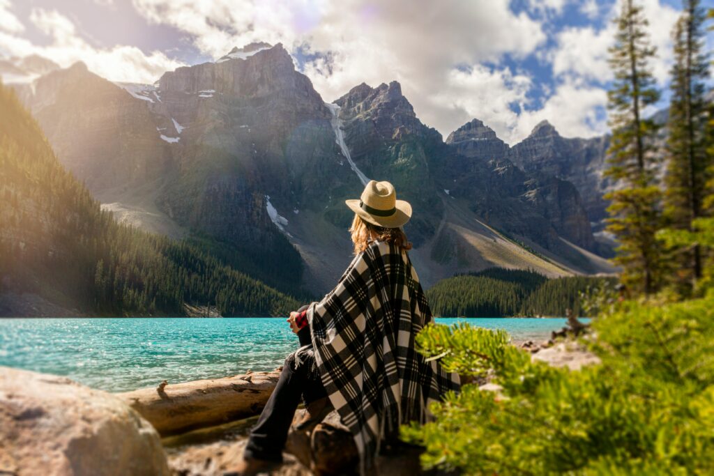 Woman Sitting on a beach looking out at the river and mountains