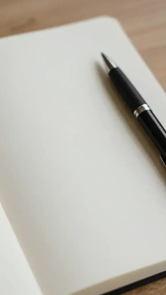 Closeup of a notebook and pen with a calm journaling setup in soft light