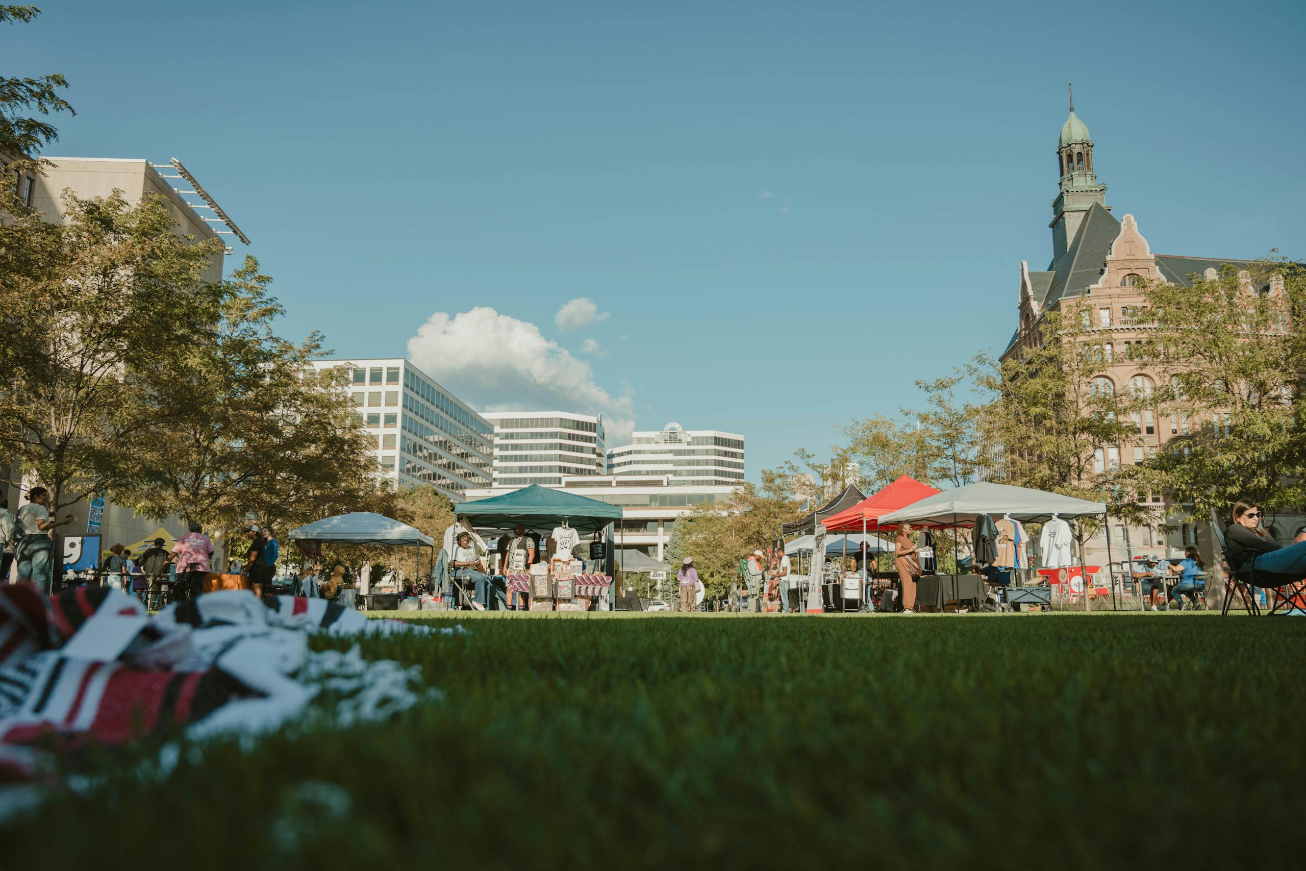 Vibrant outdoor market in Milwaukee, showcasing local vendors and architecture under clear skies.