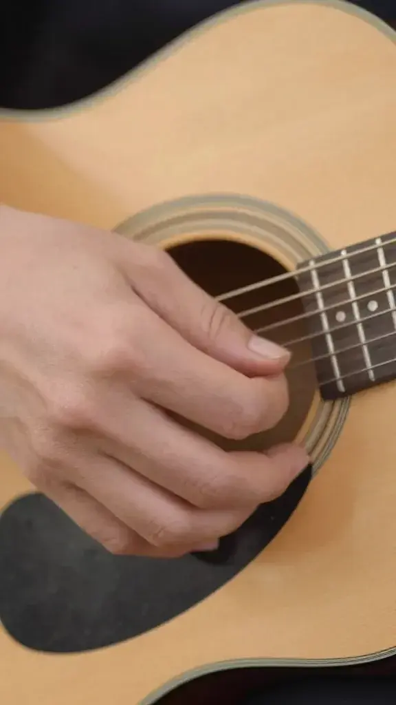 closeup of a guitar chord being fingered for a tiny weekly goal