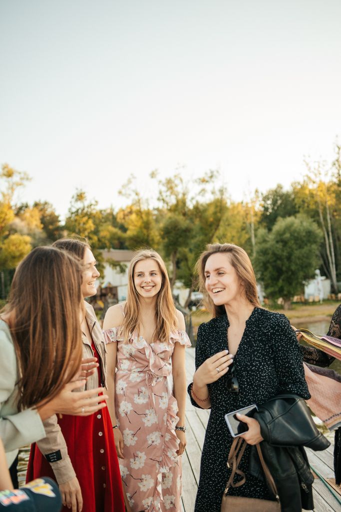 A lively group of young women enjoying a joyful conversation outdoors on a sunny day. galentines day activities