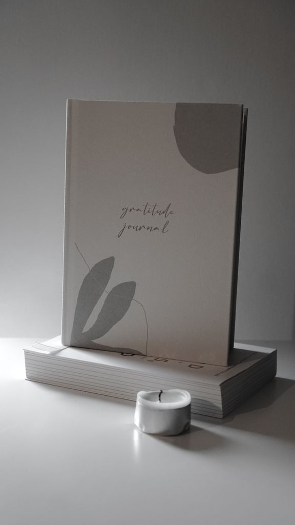 A daily gratitude journal ideas displayed on a grey background with soft lighting.