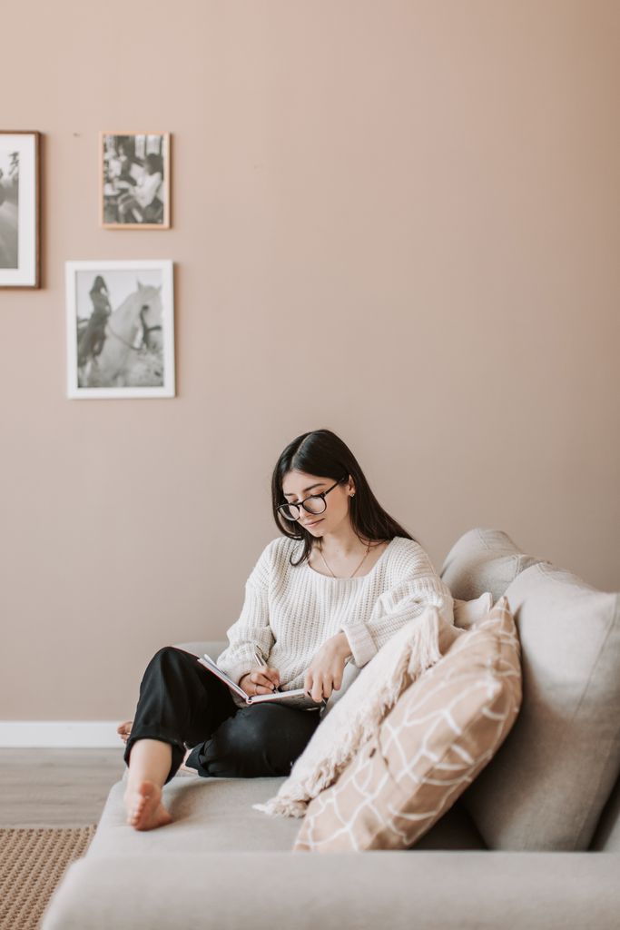 A serene indoor scene of a woman writing in a notebook, embracing leisure.