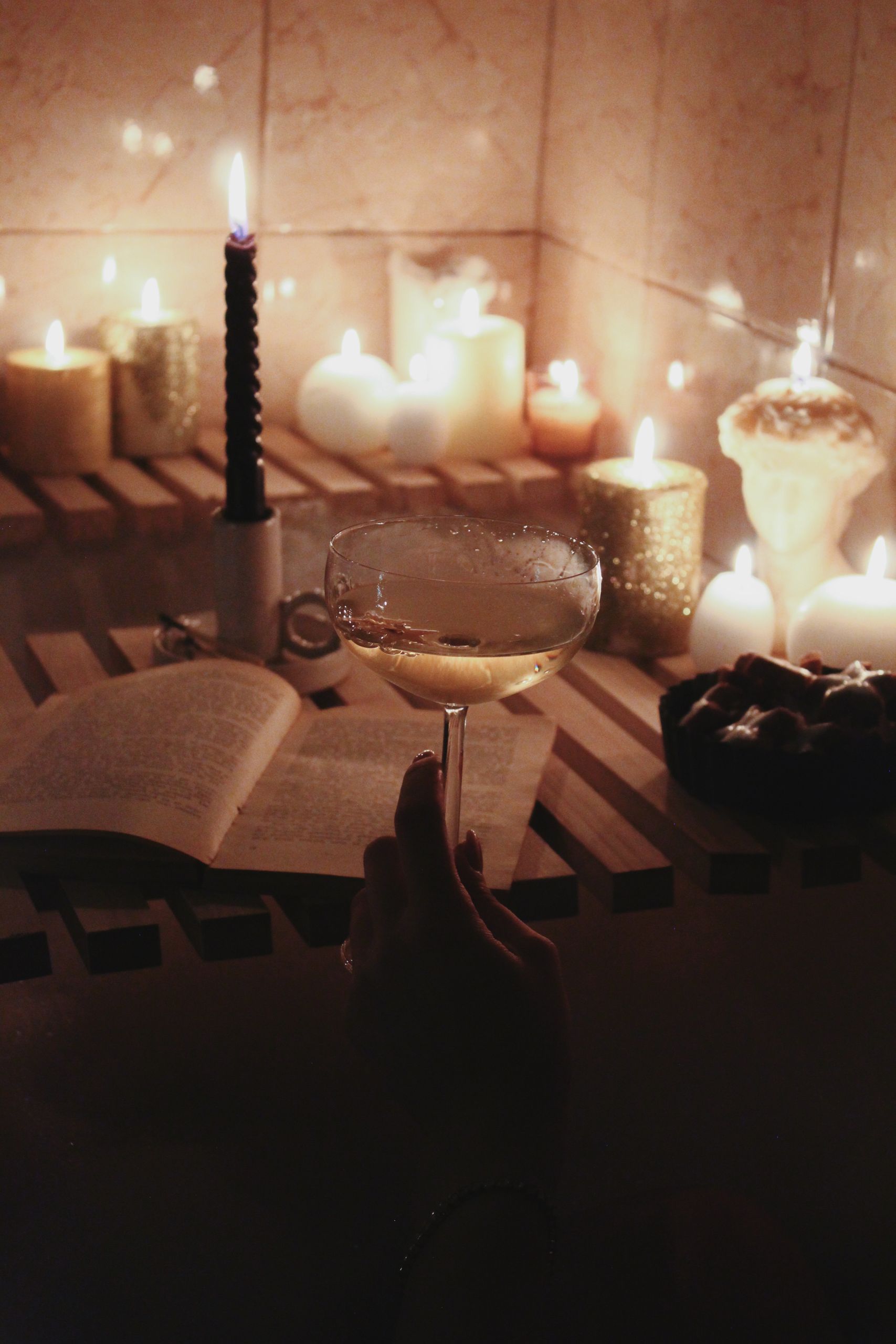 A serene setup of a bathtub with candles, champagne, and a book, evoking a sense of relaxation.