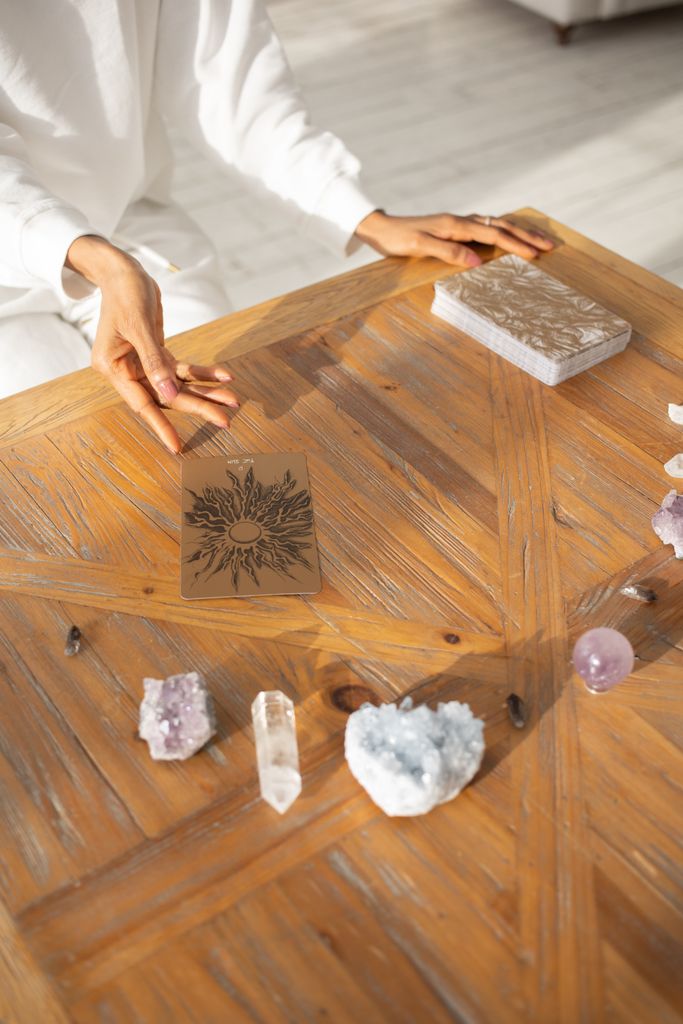 A serene tarot card reading session with crystals on a wooden table, captured from above.