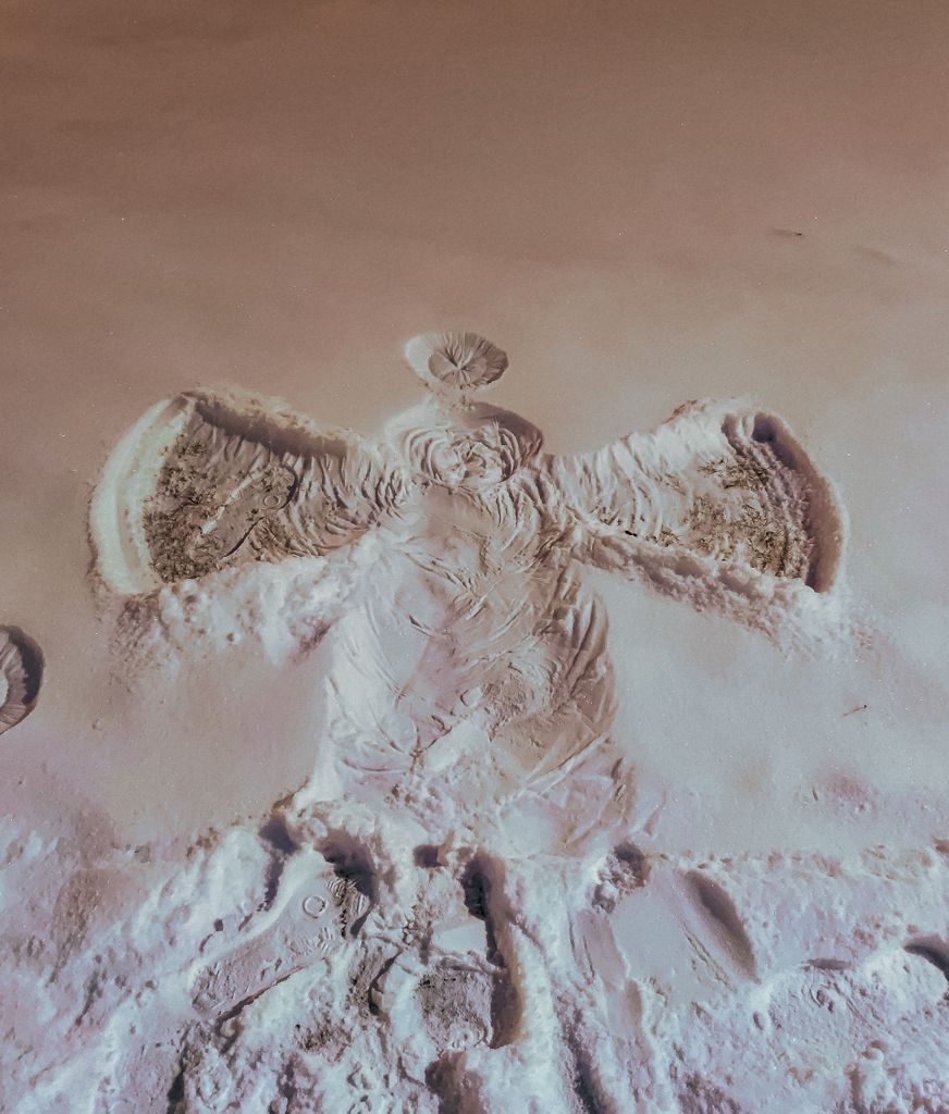 A snow angel impression on a snowy ground in Sweden during winter.