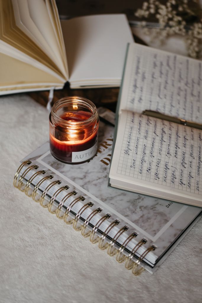 A warm candlelight scene with open journals and handwritten notes, perfect for study or reflection. manifestation scripting