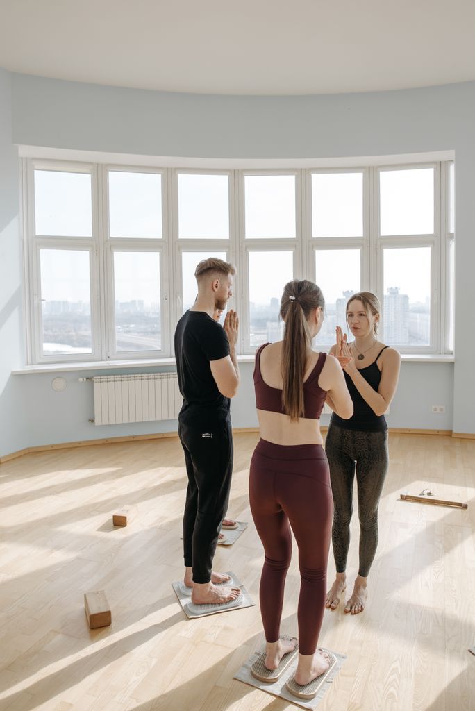 Adults engaging in a yoga session indoors, focusing on mindfulness and meditation.self discipline tips