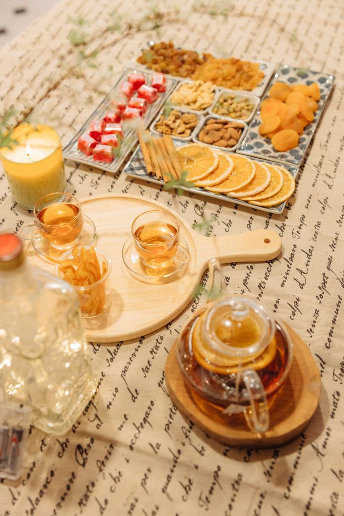 An elegant tea set with dried fruits and snacks on a decorative table setting.