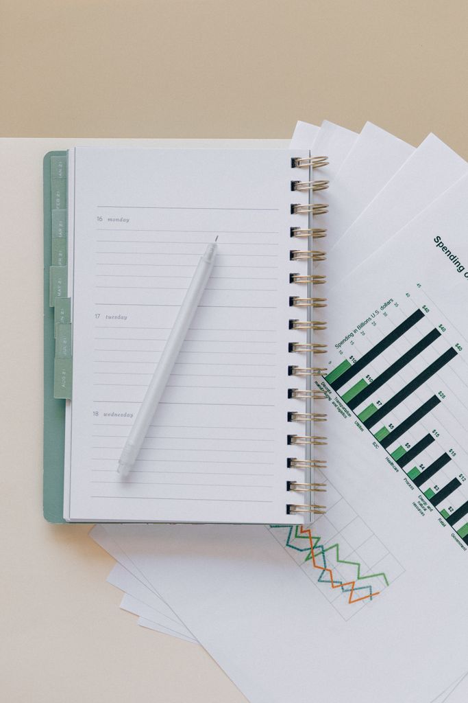 An open planner with a pen on top of graph sheets, perfect for planning and organization.goal tracking