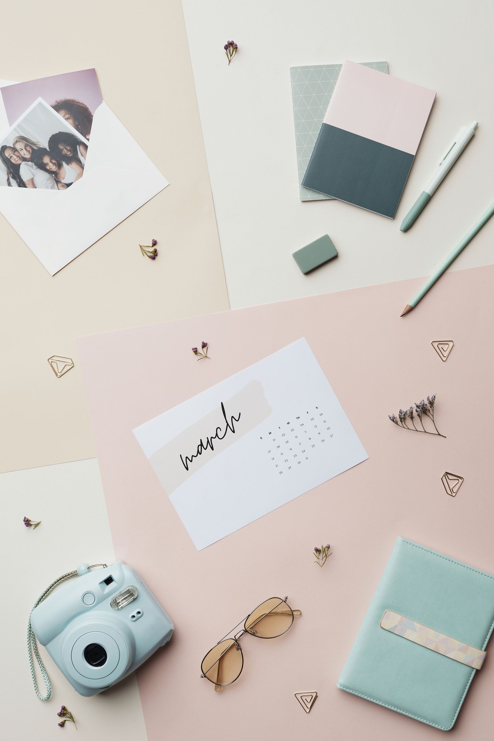 Elegant flat lay featuring stationery, a camera, and calendar for a modern office vibe.