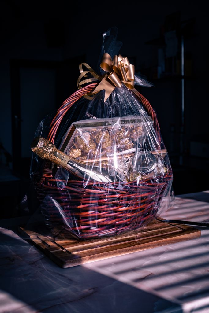 Luxurious gift basket featuring champagne and chocolates wrapped in cellophane with ribbon. self care gift basket ideas for women