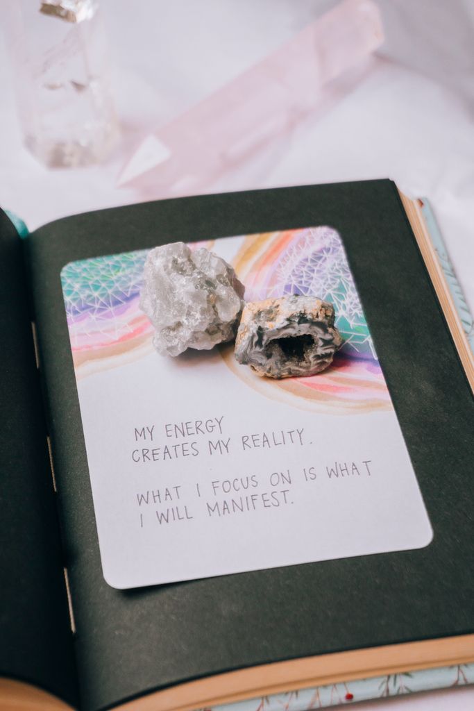 Open journal featuring crystals and an inspiring manifestation quote, perfect for motivation seekers new years manifestation