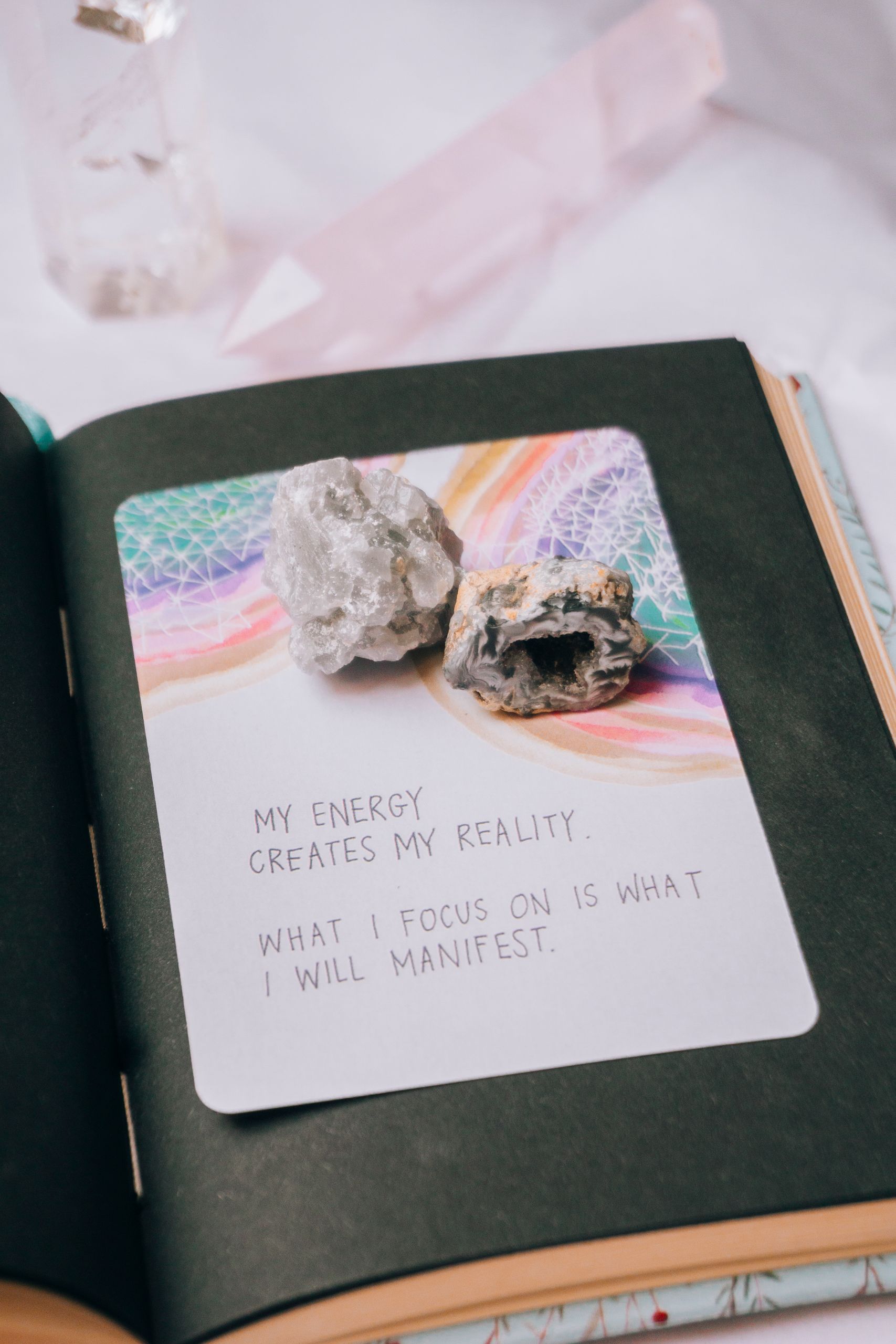 Open journal featuring crystals and an inspiring manifestation quote, perfect for motivation seekers.