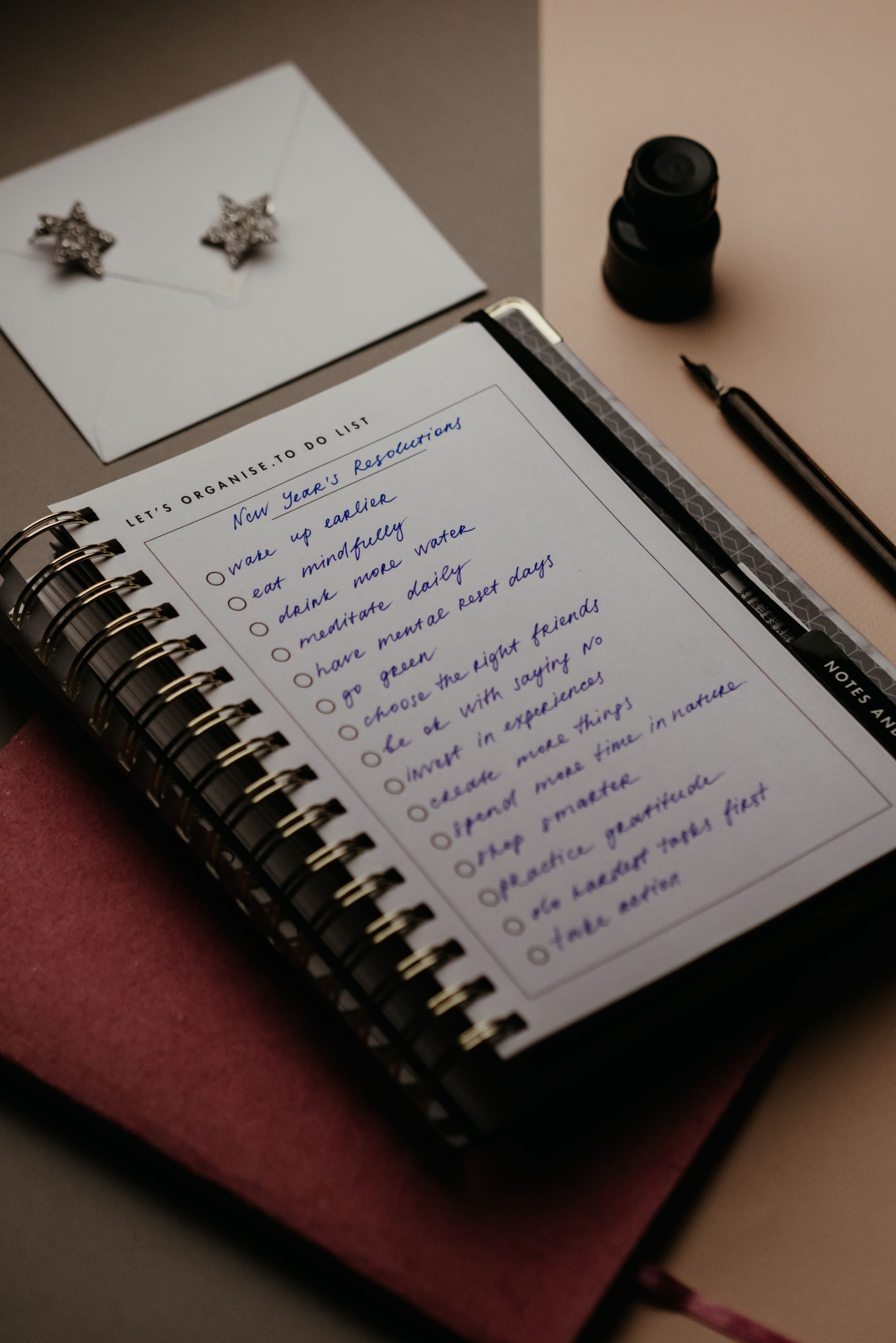 Spiral notebook with New Year's resolutions in a cozy still life setting, perfect for planning.