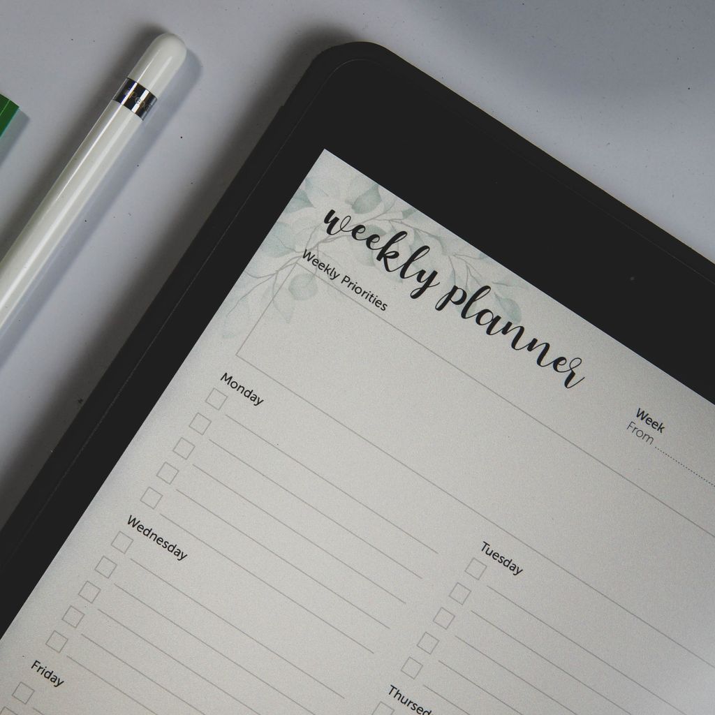 Top view of a digital tablet with weekly planner layout and stylus pen, ideal for organization.weekly reset checklist