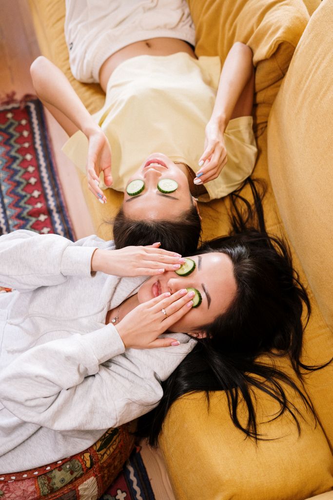 Two women enjoy a relaxing cucumber mask at home.