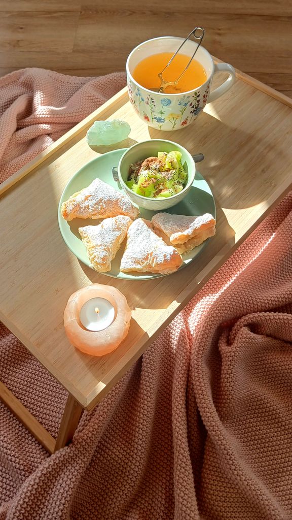Warm morning tea with powdered pastries, candlelight, and soft blankets create a cozy atmosphere.